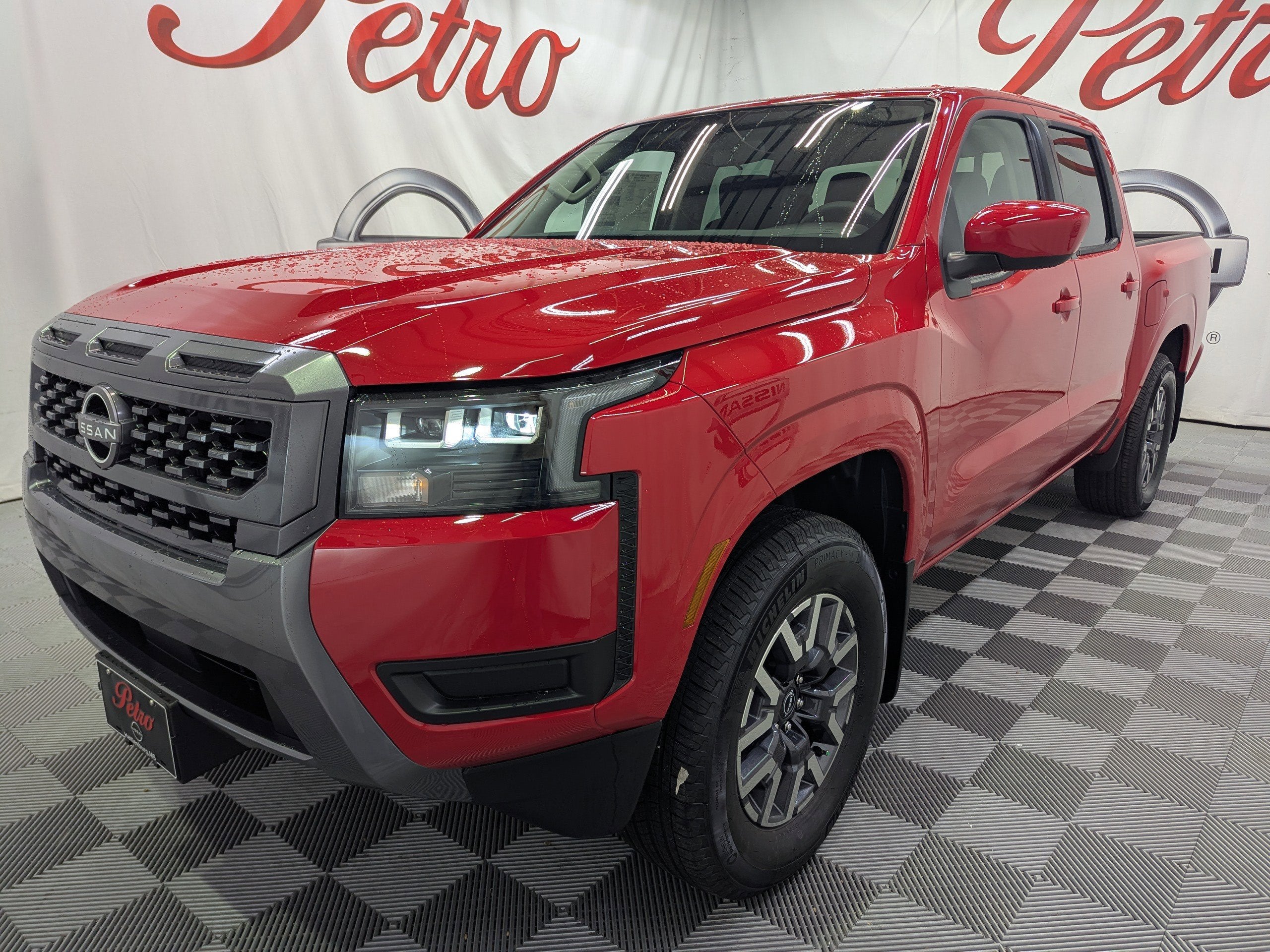 2026 Nissan Frontier SV in Red Alert — front three-quarter view